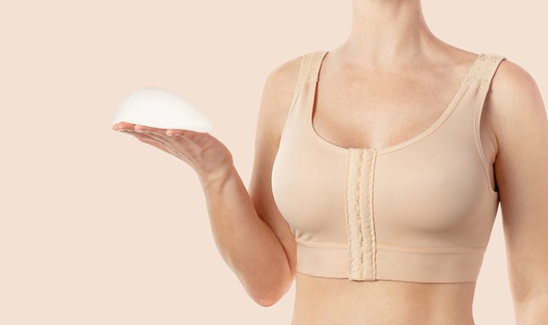 Woman wearing compressing bra after breast augmentation